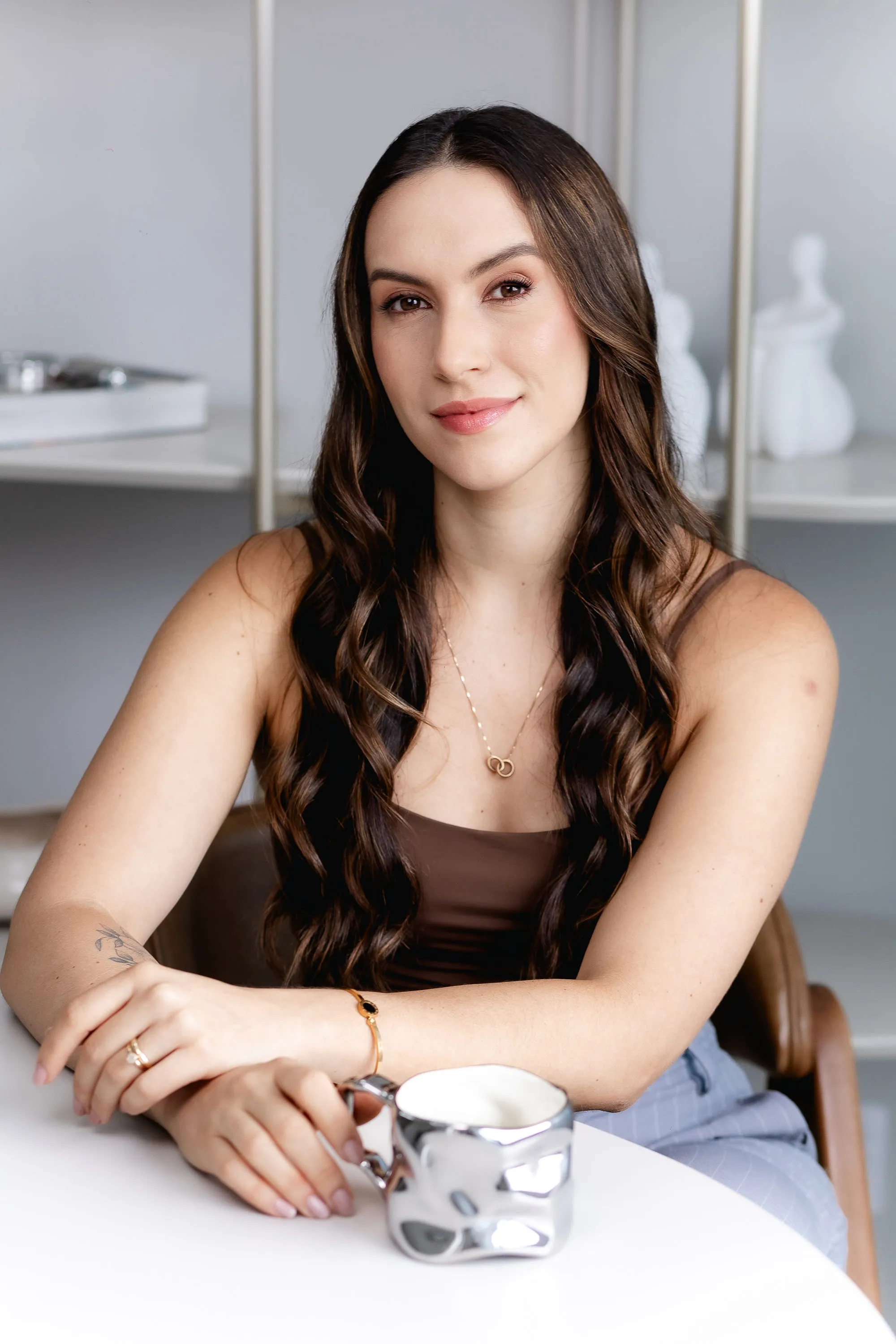 Jennifer Moneda sorrindo, sentada à mesa